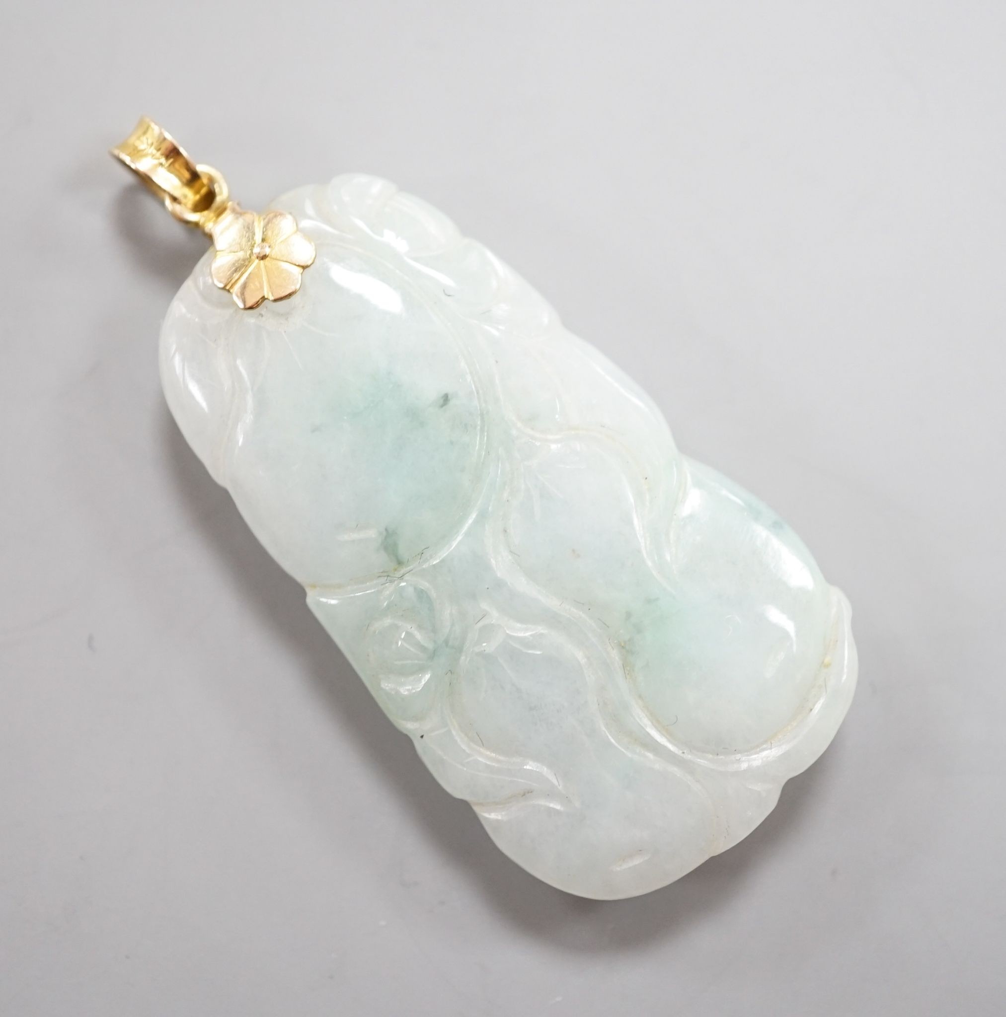 A modern 14k mounted jade plaque, carved with fruit, 44mm, gross weight 17.3 grams.